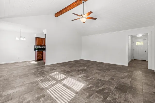 a view of a livingroom with a ceiling fan and entryway