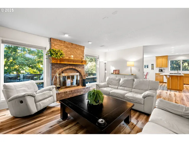 a living room with furniture a large window with kitchen view