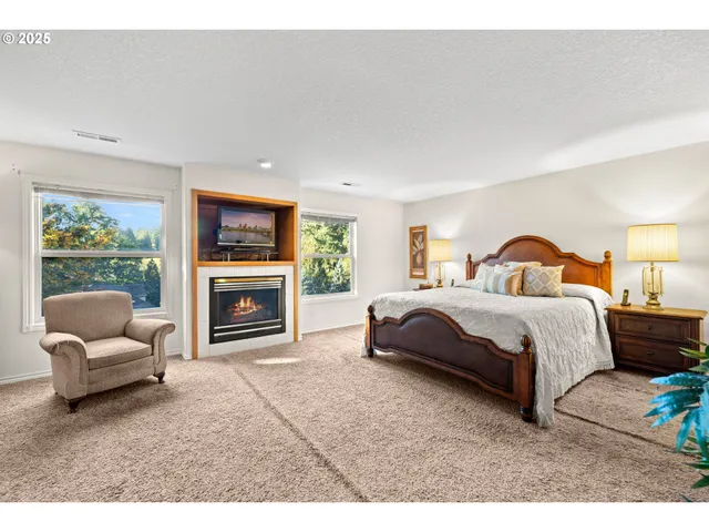 a bedroom with a bed couches and a fireplace