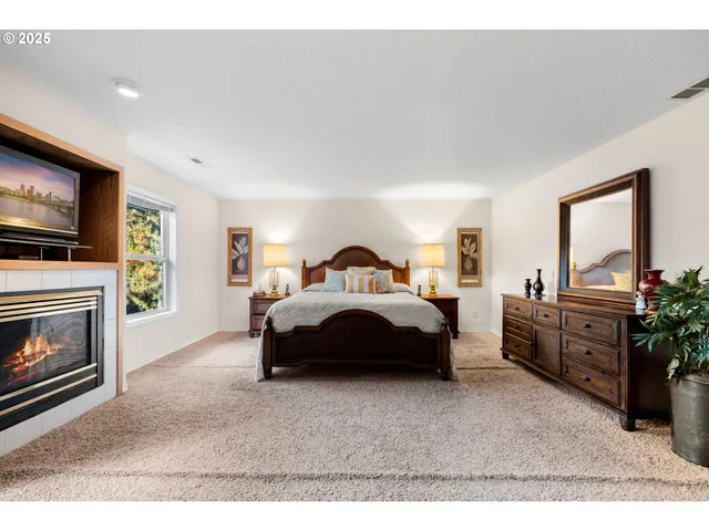 a spacious bedroom with a bed and a television