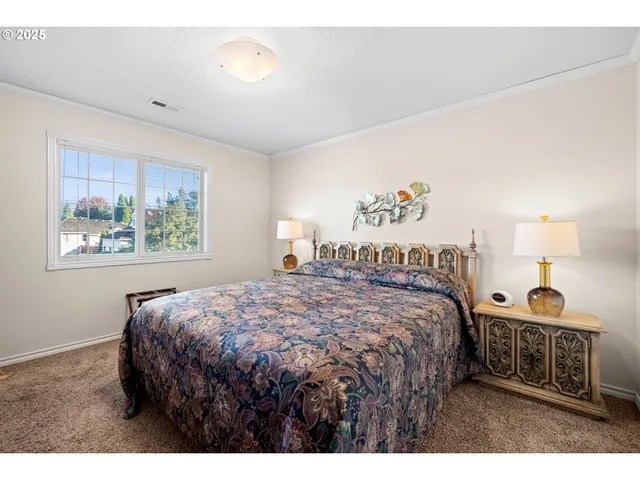 a bedroom with a bed and a painting on the wall