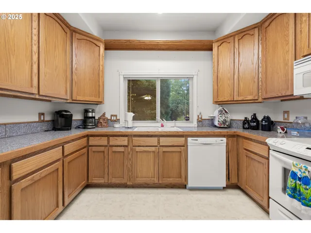 a kitchen with stainless steel appliances granite countertop a sink a stove and cabinets