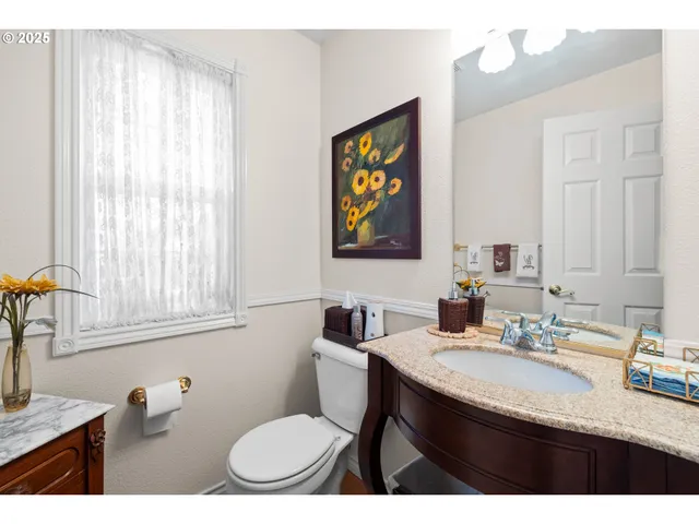 a bathroom with a granite countertop sink toilet and a mirror