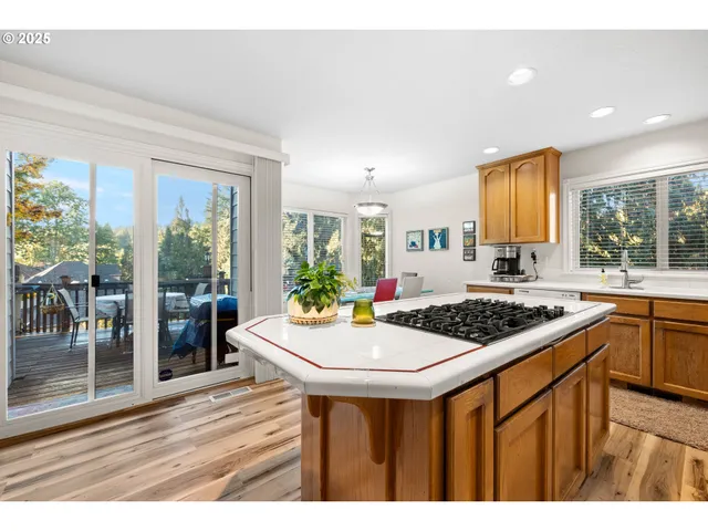 a kitchen with a stove a sink a refrigerator and wooden floor