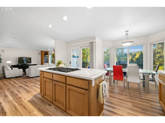a open kitchen with stainless steel appliances granite countertop a dining table chairs stove a sink and dishwasher