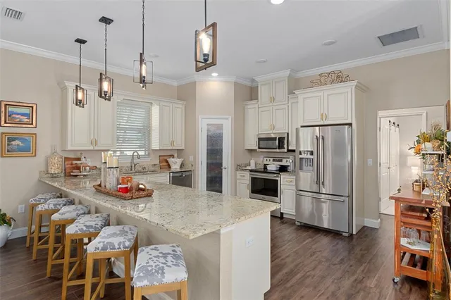 a kitchen with granite countertop appliances and wooden floor