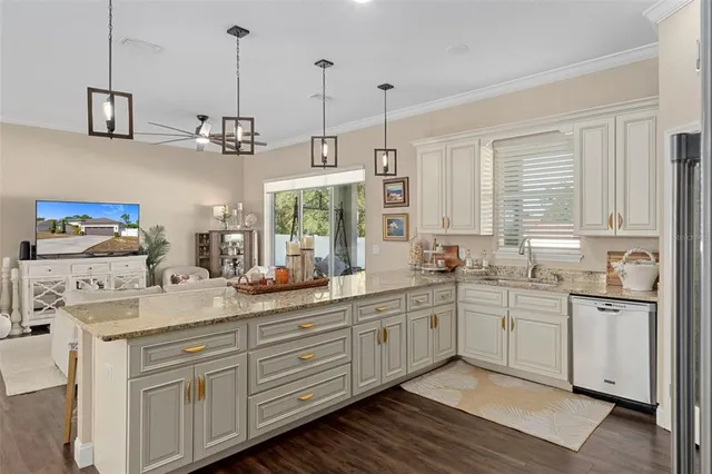 a kitchen with stainless steel appliances granite countertop a sink a stove and a wooden floors
