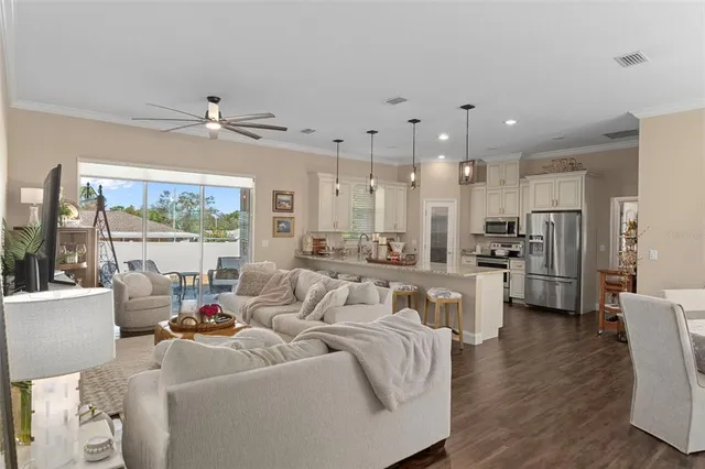 a living room with furniture wooden floor and a large window