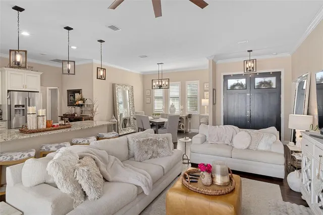 a living room with furniture kitchen view and a chandelier