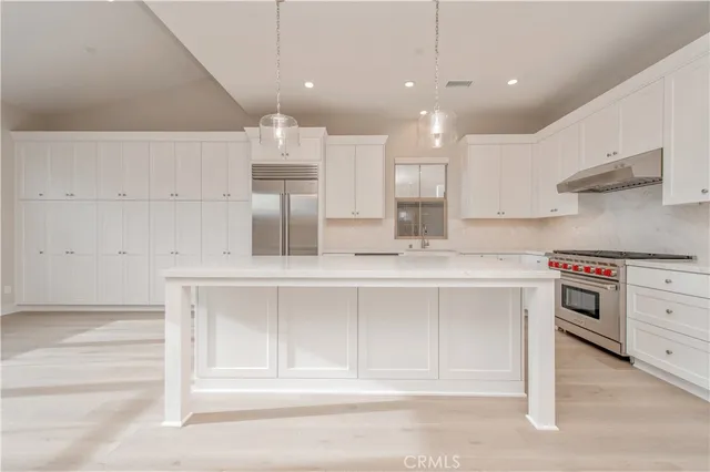 a kitchen with kitchen island white cabinets and stainless steel appliances