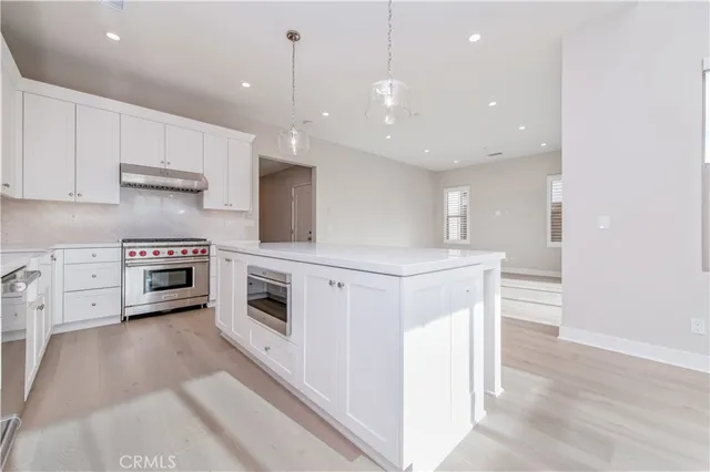 a kitchen with stainless steel appliances white cabinets and a fireplace