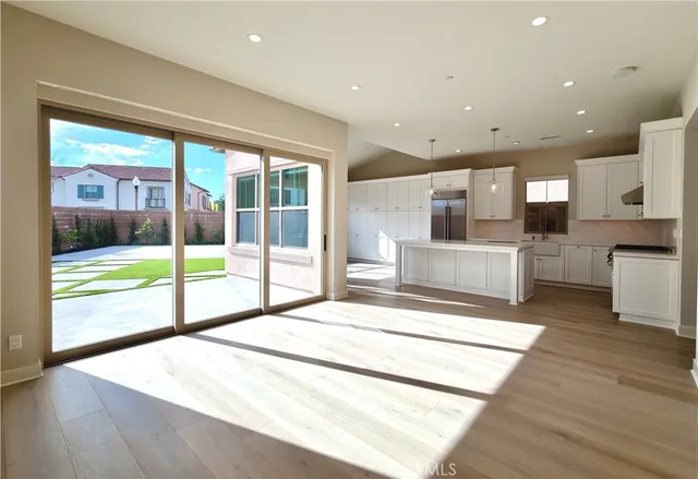 a living room with stainless steel appliances kitchen island granite countertop a refrigerator and a view of living room