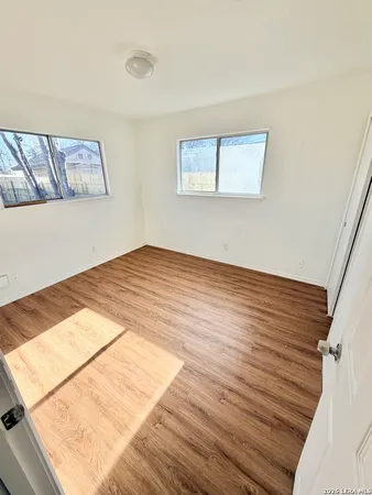 a view of a room with wooden floor and white walls