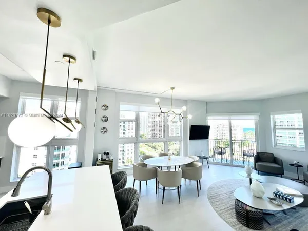 a living room with furniture a chandelier and a flat screen tv