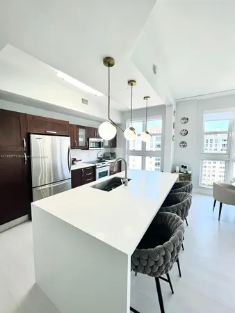 a large kitchen with a table chairs and a refrigerator