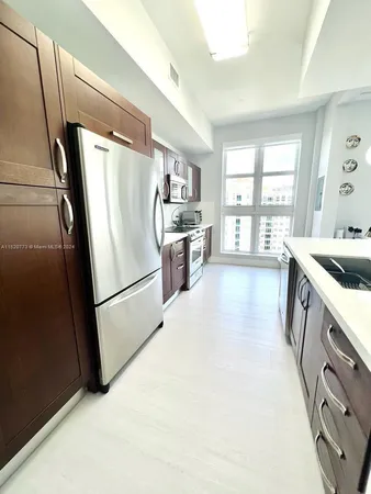 a kitchen with a refrigerator a sink a stove and cabinets
