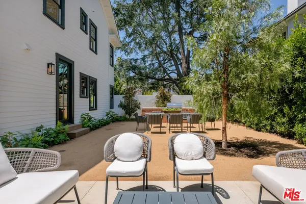 a backyard of a house with table and chairs