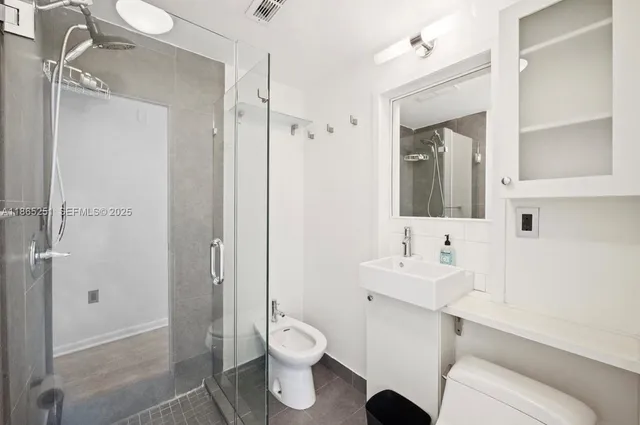 a bathroom with a sink a toilet and shower