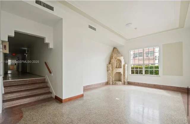 a view of empty room with stairs and windows