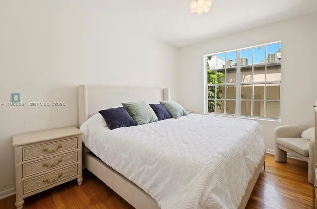 a bedroom with a bed and a window with cabinet