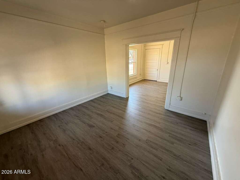 663 East 8th Street Douglas, AZ 85607 - Photo 2 of 11 a view of an empty room with wooden floor and a window