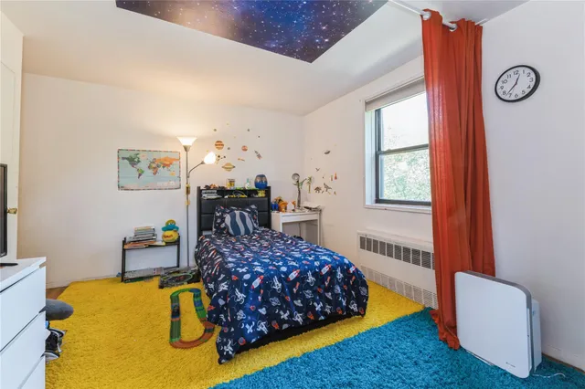 a bedroom with a bed dresser and window