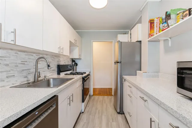 a kitchen with stainless steel appliances granite countertop a sink stove and refrigerator