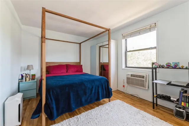 a bedroom with a bed and a dresser next to a window