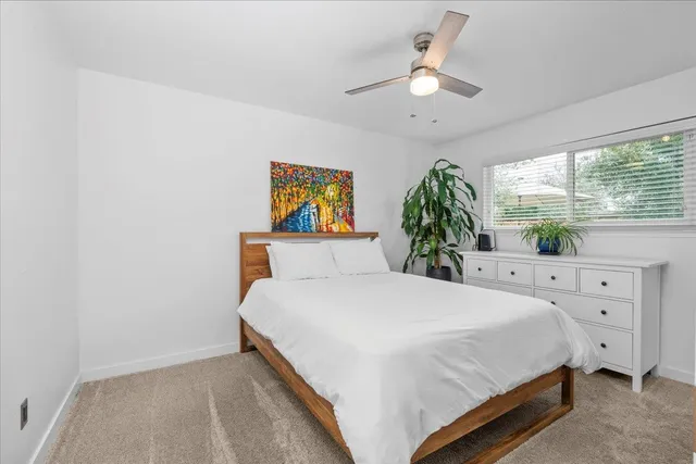 a spacious bedroom with a bed and a flat screen tv