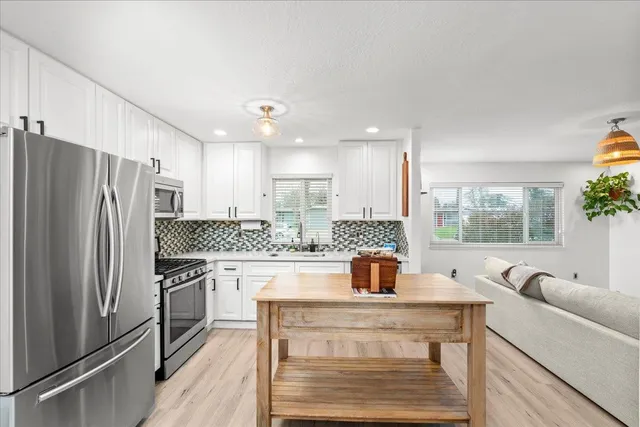 a kitchen with a refrigerator a sink and wooden cabinets