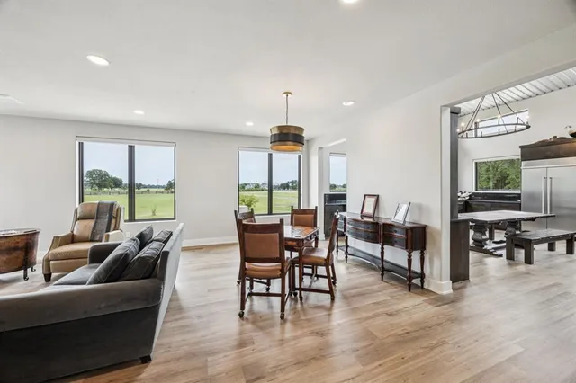 a living room with furniture dining table and a large window