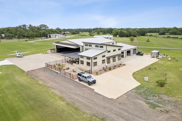 an aerial view of a house with a garden and lake view