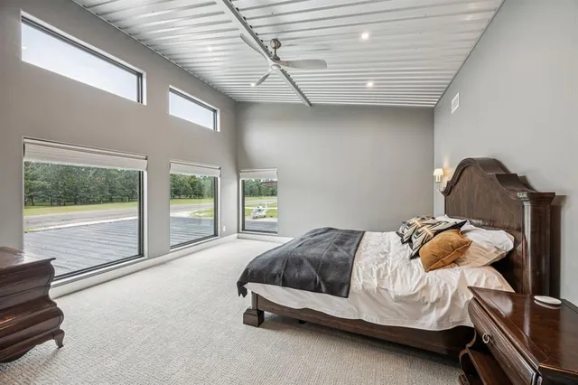 a bedroom with a bed and a large window