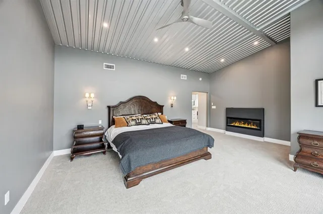 a spacious bathroom with a granite countertop sink toilet a mirror a vanity and shower