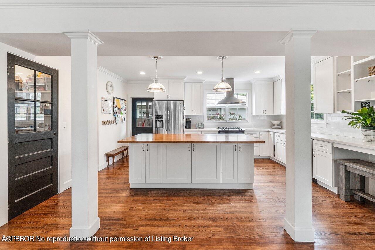 231 Argyle Road West Palm Beach, FL 33405 - Photo 4 of 17 a large white kitchen with a refrigerator a stove and a wooden floor