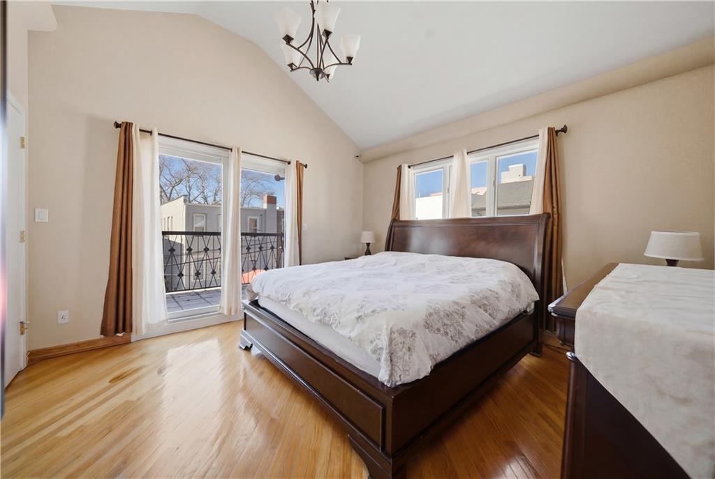 1730 East 4th Street Brooklyn, NY 11223 - Photo 18 of 24 a bedroom with a large bed a chandelier and closet