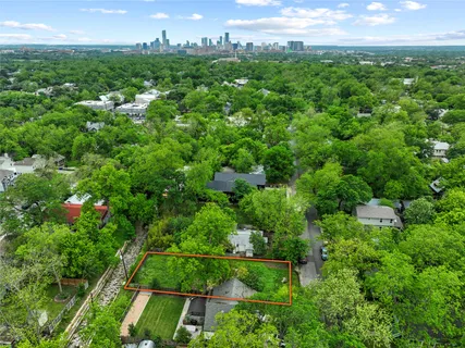 an aerial view of residential houses with outdoor space and trees