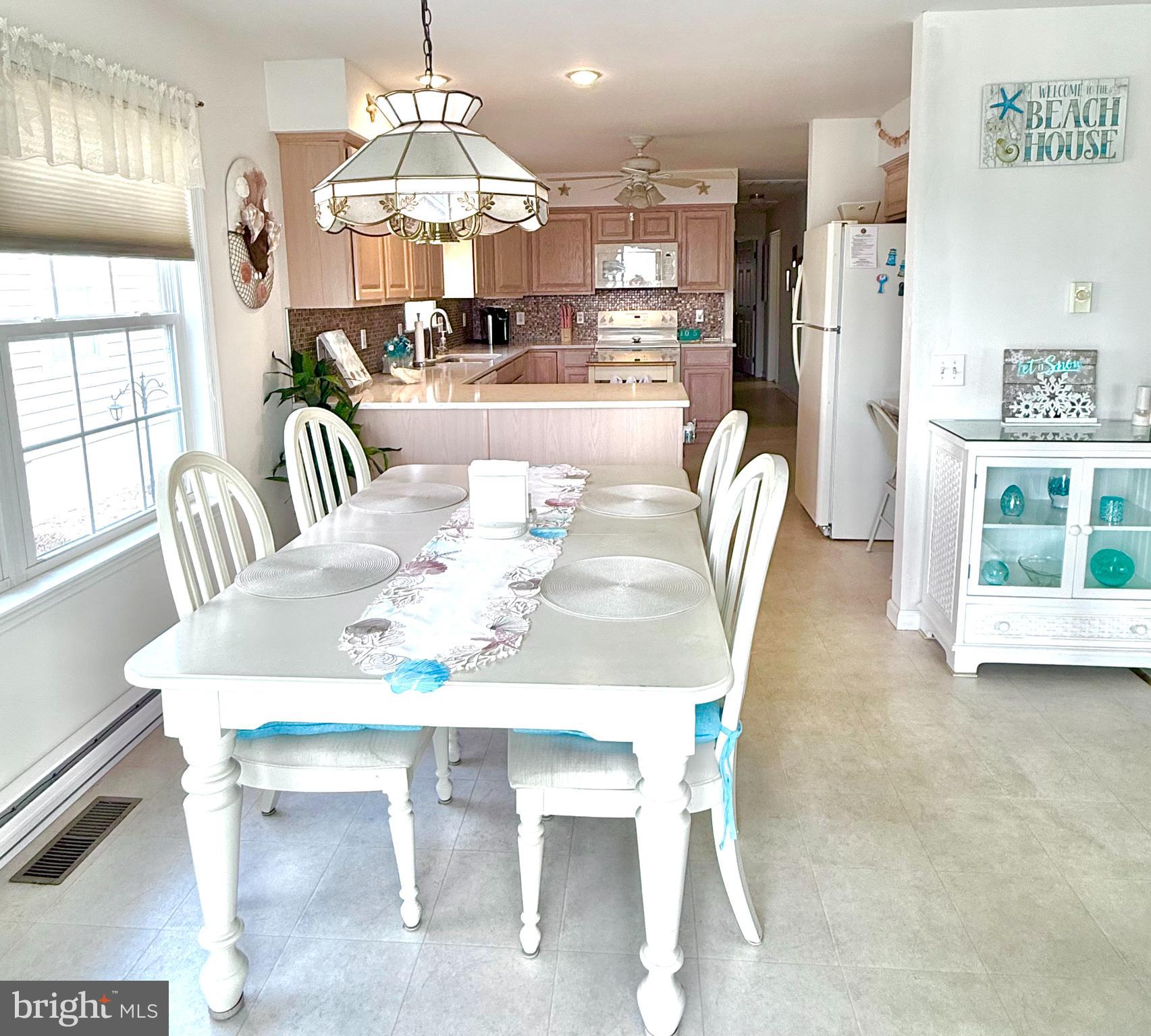 13322 Peachtree Road Ocean City, MD 21842 - Photo 17 of 54 a dining room with furniture a chandelier and wooden floor