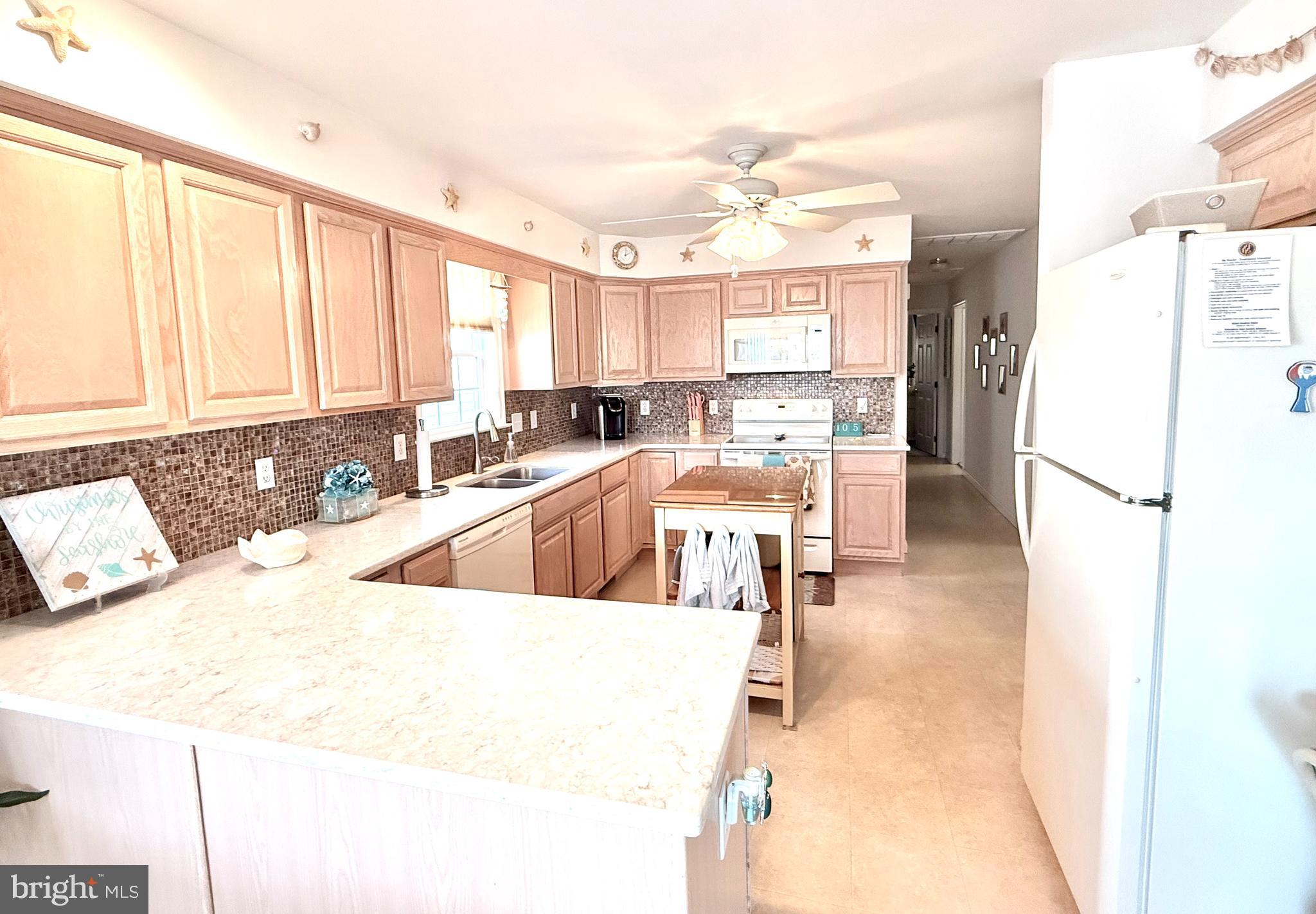 13322 Peachtree Road Ocean City, MD 21842 - Photo 19 of 54 a living room with stainless steel appliances kitchen island granite countertop furniture and a kitchen view