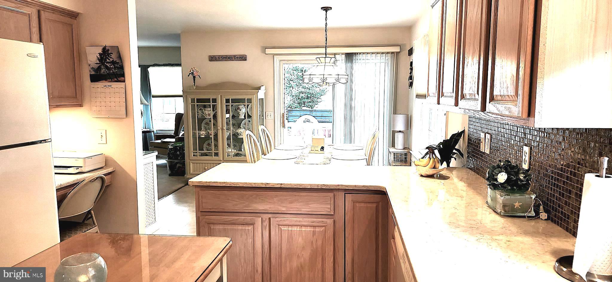 13322 Peachtree Road Ocean City, MD 21842 - Photo 22 of 54 a kitchen with a refrigerator a stove and a sink with wooden floor
