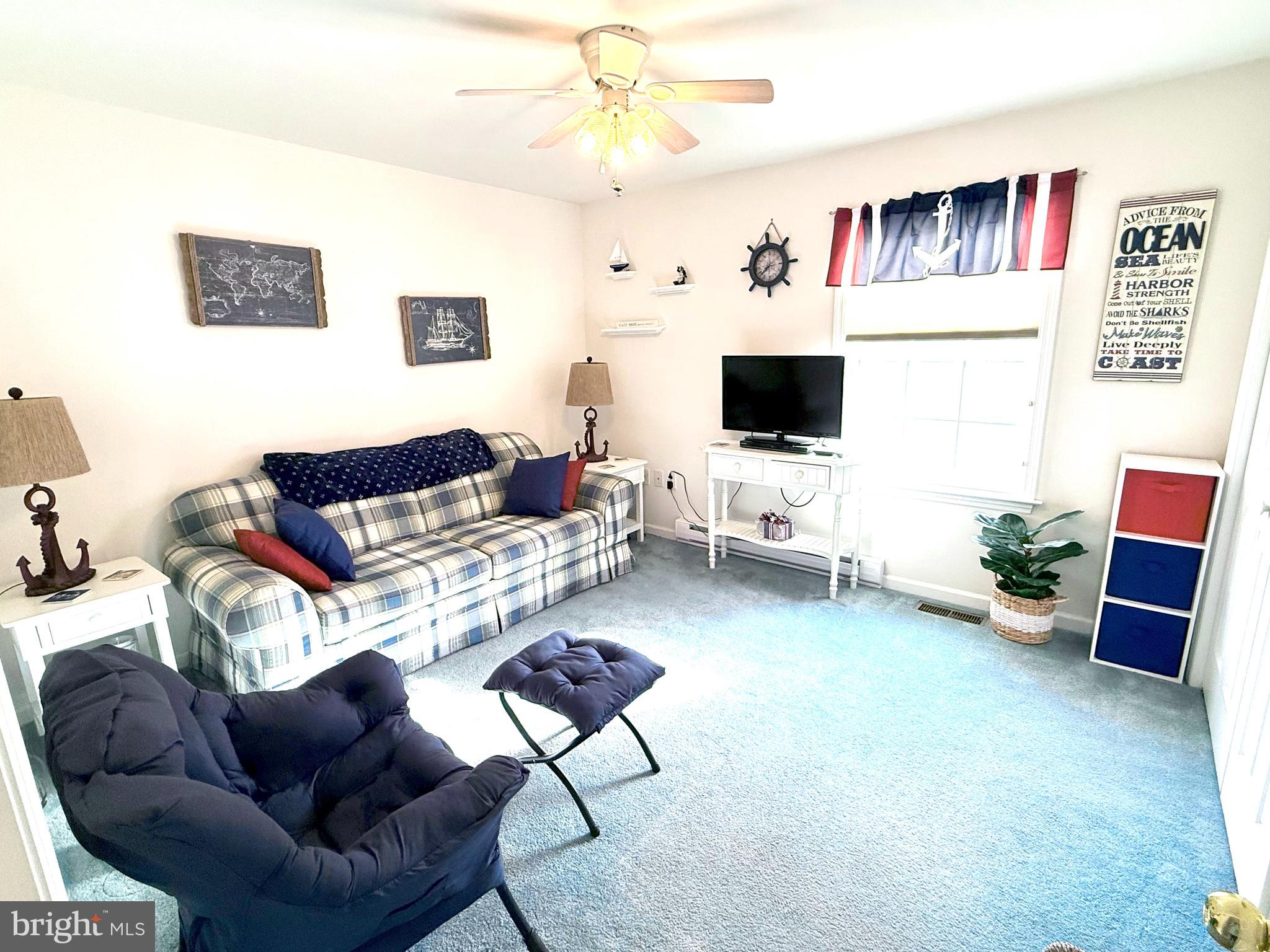 13322 Peachtree Road Ocean City, MD 21842 - Photo 32 of 54 a living room with furniture and a flat screen tv