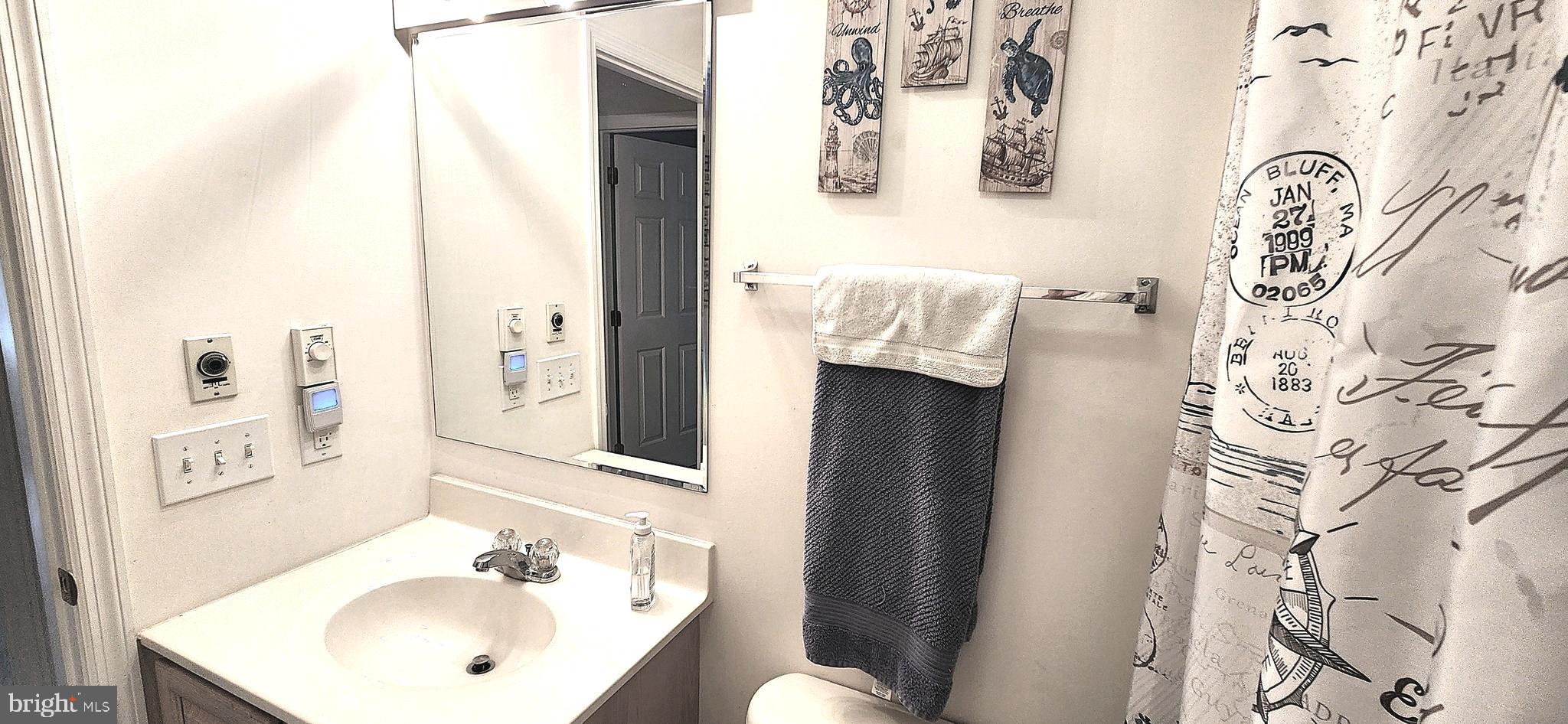 13322 Peachtree Road Ocean City, MD 21842 - Photo 36 of 54 a bathroom with a sink and mirror with toilet