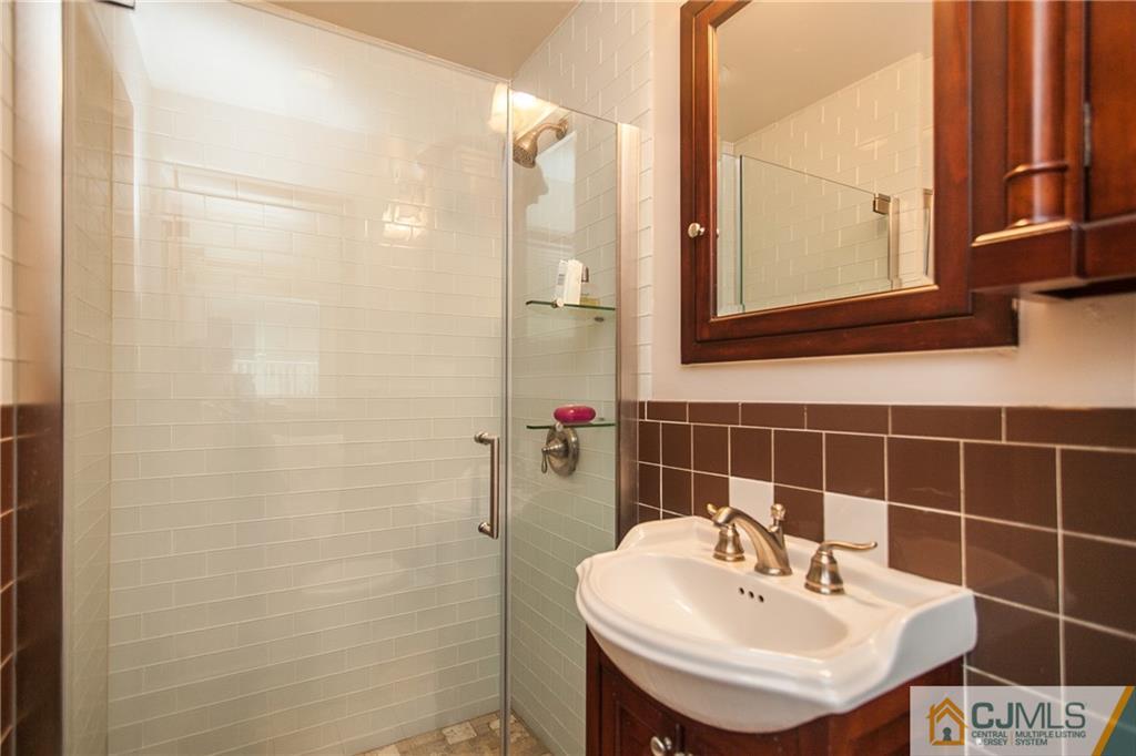 91 George Avenue Edison, NJ 08820 - Photo 11 of 21 a bathroom with a sink a shower and a mirror