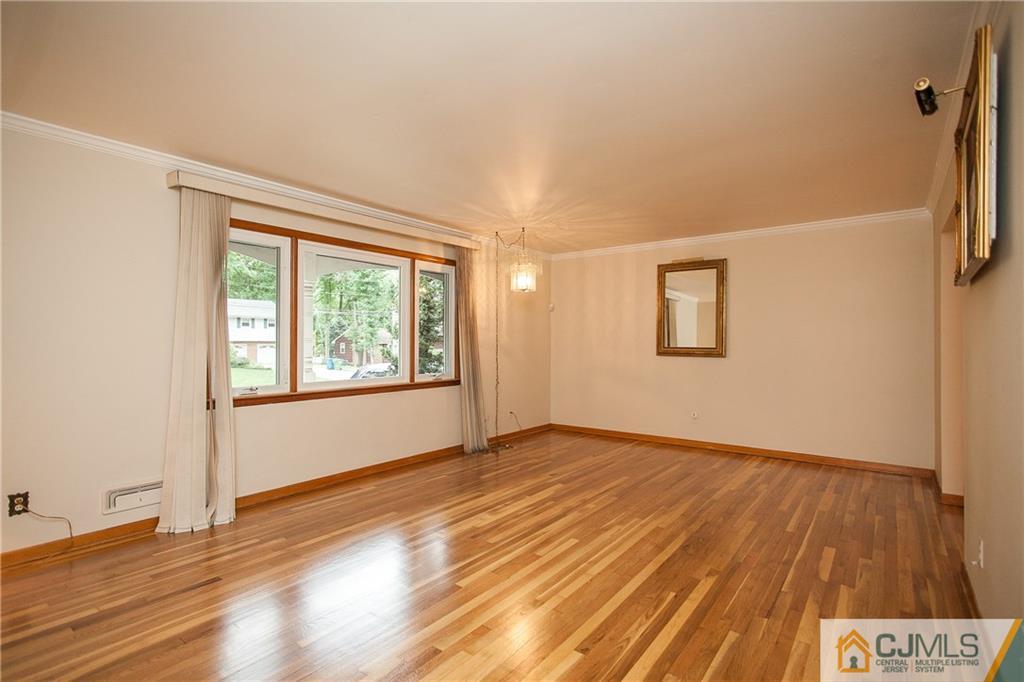 91 George Avenue Edison, NJ 08820 - Photo 3 of 21 a view of an empty room with wooden floor and a window