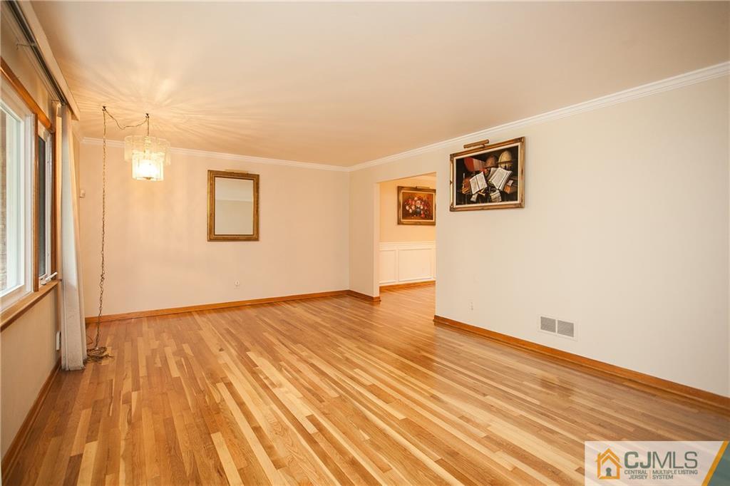 91 George Avenue Edison, NJ 08820 - Photo 4 of 21 a view of an empty room with wooden floor and a window