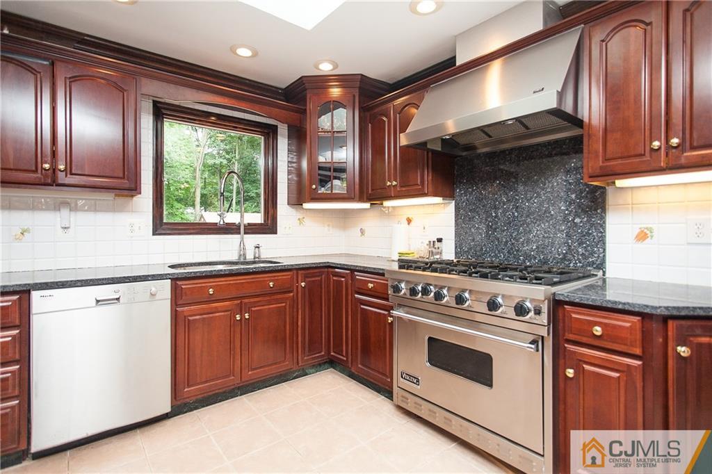 91 George Avenue Edison, NJ 08820 - Photo 5 of 21 a kitchen with granite countertop stainless steel appliances wooden cabinets and a stove top oven