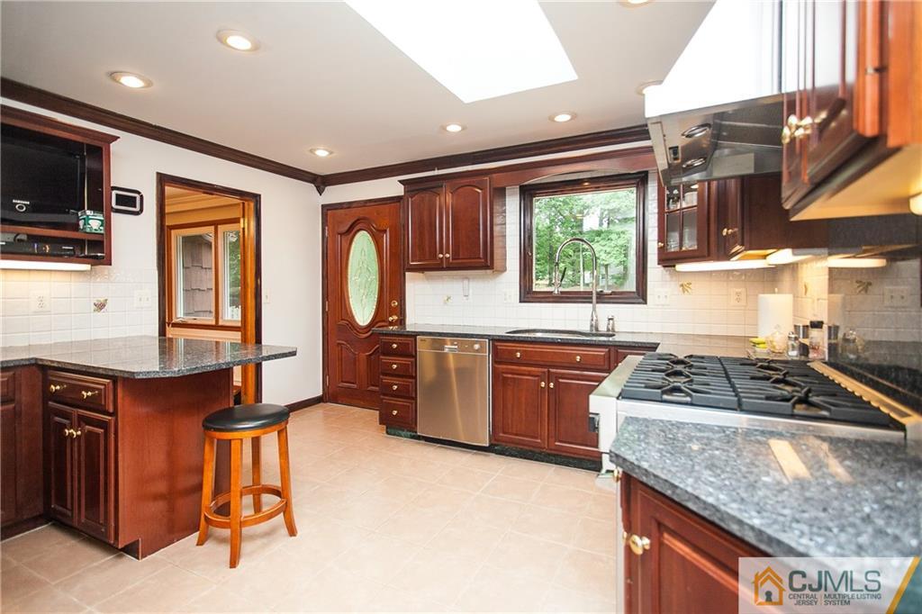91 George Avenue Edison, NJ 08820 - Photo 6 of 21 a kitchen with granite countertop a stove a sink and a refrigerator