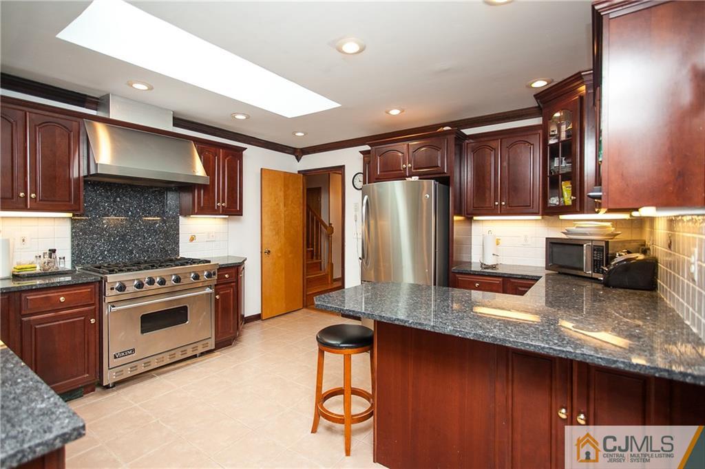 91 George Avenue Edison, NJ 08820 - Photo 7 of 21 a kitchen with stainless steel appliances granite countertop a sink stove and refrigerator