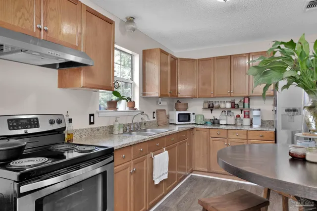 a kitchen with a sink a stove and cabinets