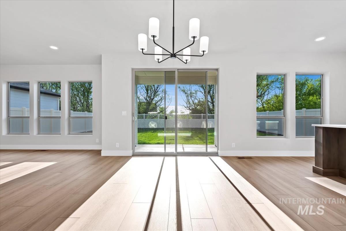 4223 Tropic Way Caldwell, ID 83607 - Photo 12 of 42 Spacious interior featuring wood-finish flooring, a contemporary chandelier, recessed lighting, and multiple windows